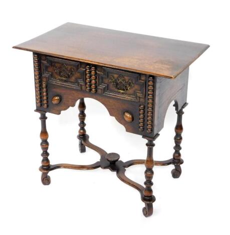 A 17thC style oak side table, with two frieze drawers, above a recessed apron, raised on turned legs and scroll feet, united by an X frame stretcher, 71.5cm H, 75cm W, 45cm D.