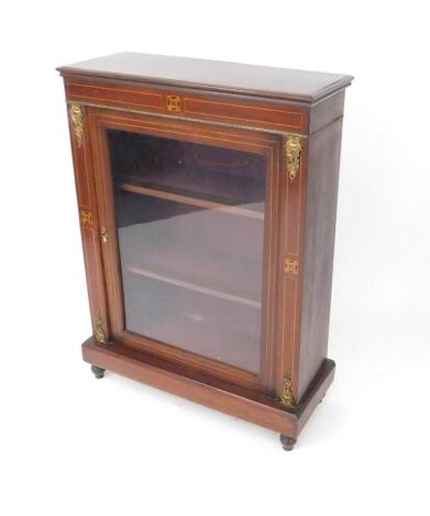 A Victorian mahogany and inlaid pier cabinet, with brass mounts, single glazed door opening to reveal two shelves, raised on a plinth base and turned feet, 104cm H, 75cm W, 30.5cm D.