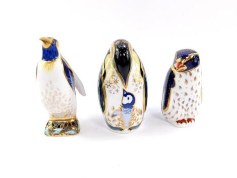 A Royal Crown Derby imari paperweight, modelled as an Emperor penguin, further paperweight modelled as a penguin and chick, boxed., and a third paperweight modelled as a rock hopper penguin, boxed with certificate. (3)