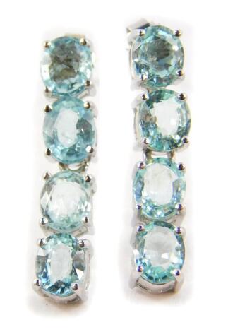 A pair of 18ct white gold and Paraiba tourmaline drop earrings, each set with four oval cut stones, with certificate, 5.0g.