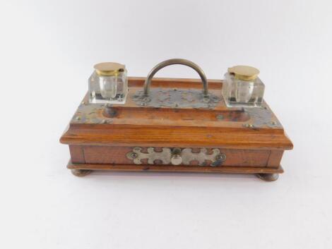 A Victorian oak and brass mounted desk stand, with a pair of facetted cut glass inkwells with brass hinged lids, single frieze drawer, raised on bun feet, 28cm W, 17cm D.