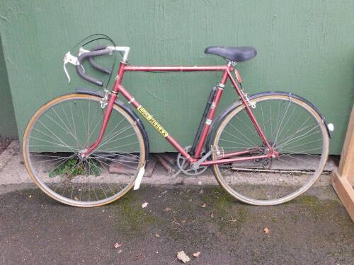 A Supabikes Super Prestige Eddy Merckx road bicycle, maroon with Eddy Merckx decals.