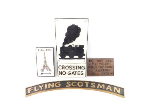 Three reproduction cast iron railway way signs, comprising Flying Scotsman., Crossing No Gates., and Do Not Use The Toilets While The Train Is Standing In The Station., together with a cast iron Le Tour Eifel Sign. (4)