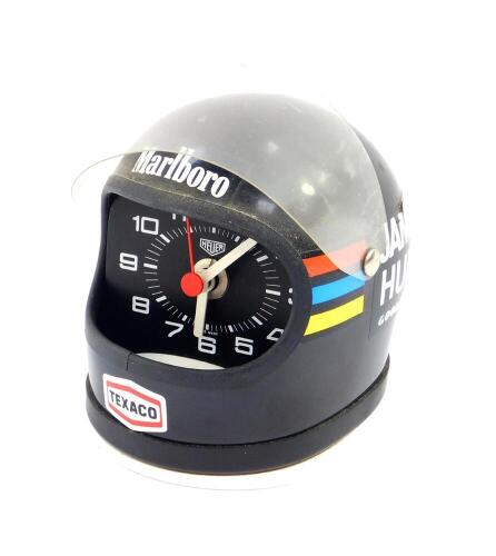 A Heuer desk clock modelled as James Hunt's helmet, black with decals, battery operated.