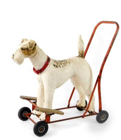 A Tri-ang push-a-long dog, the moulded plastic terrier mounted on red metal frame, 61cm H.