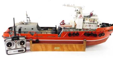 A kit built remote controlled model of a boat Aziz, red hull, with Planet digital control, 41cm H, 112cm L.