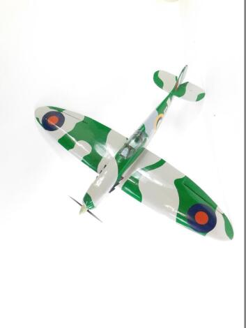 A kit built model of a Spitfire, camouflage painted, with military decals, 110cm L, 145cm W.