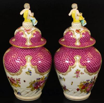 A pair of Meissen porcelain vases and covers, each exquisitely decorated with flowers, with domed circular lids surmounted by cherub and garland finials, each main body decorated with feathered pink and purple panelling, with further handpainted flowers o - 3