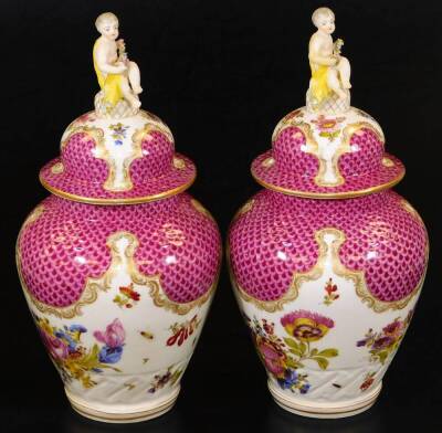 A pair of Meissen porcelain vases and covers, each exquisitely decorated with flowers, with domed circular lids surmounted by cherub and garland finials, each main body decorated with feathered pink and purple panelling, with further handpainted flowers o - 4