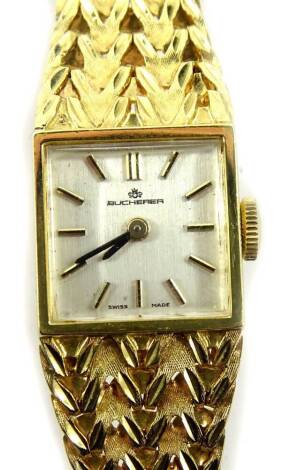 A Bucherer ladies wristwatch, with small square silvered colour dial, with raised V shaped design bracelet, yellow metal, marked 750, 19cm L overall, 32.3g all in.