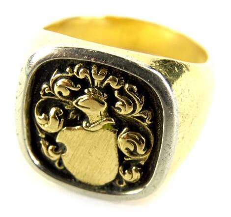 A gentleman's signet ring, with central square crest depicting a coat of arms and feathers, with a silver coloured outer rim, yellow metal, marked 750, ring size T½, 24.8g all in.