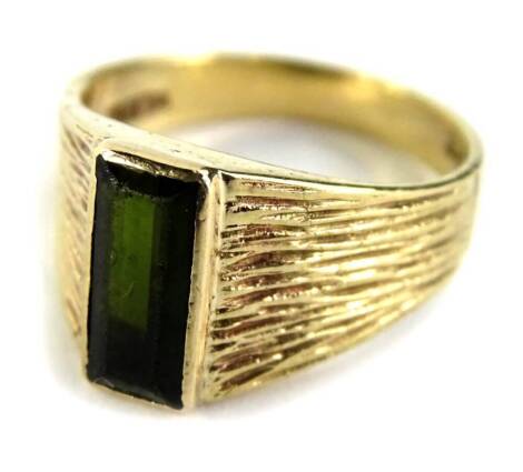 A textured yellow metal ring, set with a rectangular tourmaline, stamped 9ct, 3.8g all in.