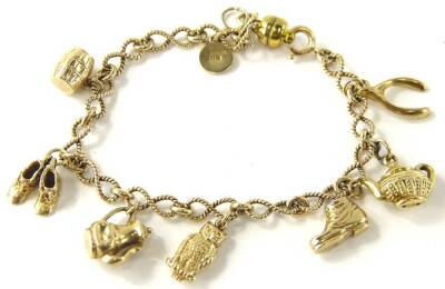 A 9ct gold charm bracelet, with eight charms, some marked 9ct some unmarked, including a medallion, barrel, shoes, kettle, owl, wishbone, shoe and coffee pot, on a curb link bracelet, 19cm long overall, 13.6g all in.