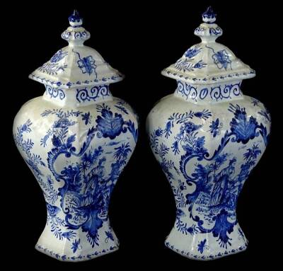 A pair of 17thC style Dutch Delft vases and covers, each with inverted shoulder bodies, decorated with oriental figures and flowers, probably early 20thC, painted marks beneath, 29cm H.