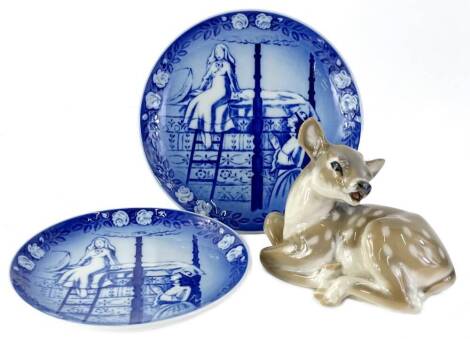 A 20thC Royal Copenhagen figure of a recumbent fawn, number 2609, printed marks beneath, 13cm H, and two Copenhagen calendar plates for 1986. (3)