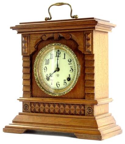An early 20thC oak cased mantel clock, the heavily carved case on bracket feet, with eight day movement, 36cm H.