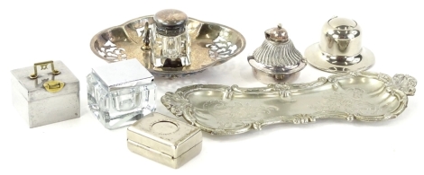 An early 20thC plated pen stand, of inverted figure of eight form, raised with scrolls and shells, with central fern leaf and scroll decoration, 24cm W, a small quantity of other chrome plated and other glass inkwells. (a quantity)