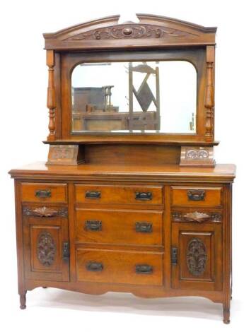 A Victorian walnut sideboard, the raised back with an arched bevel mirror plate, flanked by turned supports, the base with an arrangement of five drawers and two carved panel doors, on turned feet, 140cm W.