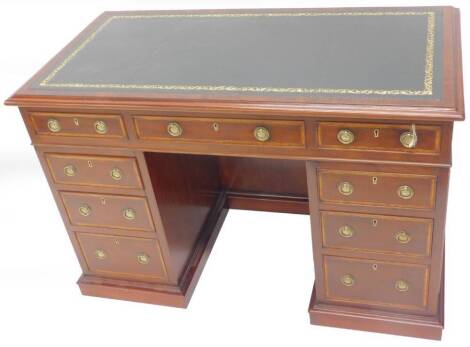 A narrow mahogany pedestal desk, the rectangular top with a green leather inset and a moulded edge above and arrangement of nine drawers each with brass ring handles on a plinth base, 116cm W.