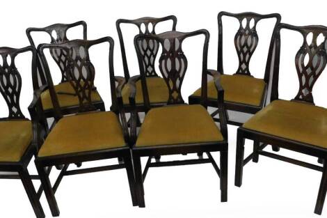 A set of six mahogany dining chairs in George III style, each with a pierced splat and a drop in seat on channelled legs, two with arms. The upholstery in this lot does not comply with the 1988 (Fire & Fire Furnishing) Regulations, unless sold to a known 