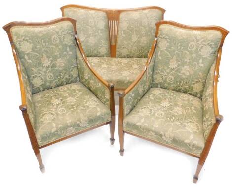 An Edwardian mahogany and marquetry three piece suite, comprising two seat sofa with padded back sides and seat, the shaped show frame with boxwood stringing and pierced central splat and two matching armchairs, each on square tapering legs.