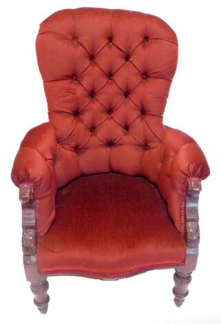 A Victorian mahogany armchair, with a buttoned padded back and back sides and seat on turned legs with ceramic castors.