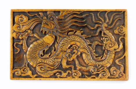 A 20thC Chinese rectangular soapstone plaque, with carved relief of a celestial dragon, flames and clouds, 20cm x 12cm.