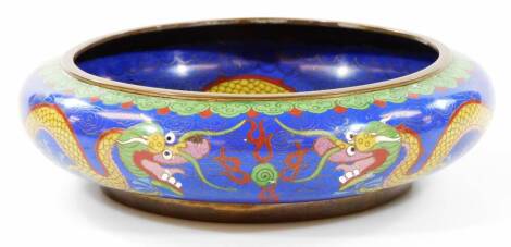 An early 20thC Chinese cloisonne bowl, of circular form, decorated with front facing dragon in yellow, green and red on a blue ground, the reverse with four character Ming mark, 26cm Dia.