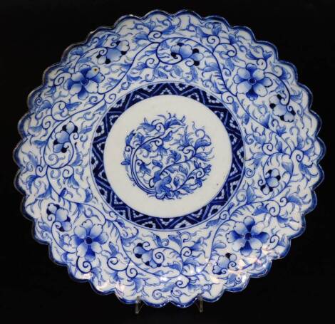 A Japanese porcelain dish, of floral form, profusely decorated with flowers and geometric designs, on a circular foot with decoration verso, 30cm W.