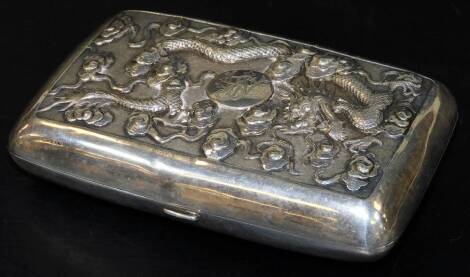 A 19thC Chinese Canton white metal repousse cigarette case, decorated with dragons and clouds around an engraved central cartouche, the reverse with a chrysanthemum branch gilt interior cartouche initialled and a part gilt interior, marked SILVER, WA and