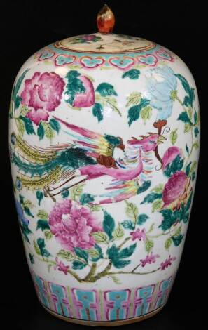 A Chinese porcelain ovoid jar and cover, decorated in famille rose palette with phoenix flying among peonies, between ruyi and lappet borders, unmarked, on a turquoise glazed base, 34cm H.