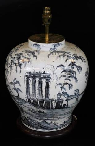 A bulbous vase lamp, delicately decorated with ruin and trees in black on a wooden plinth base with electrical fitting, 49cm H.