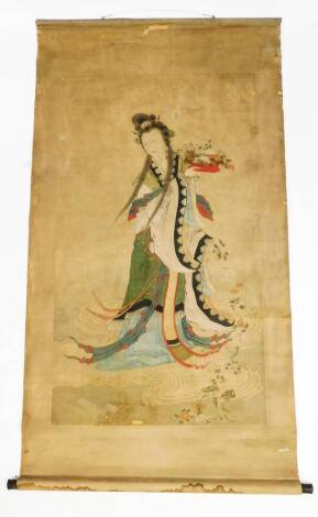 A Chinese scroll, painted with the figure of the goddess of compassion Guan Yin standing on a cloud and tossing flowers to the Earth below. probably 18th century, 89cm W.
