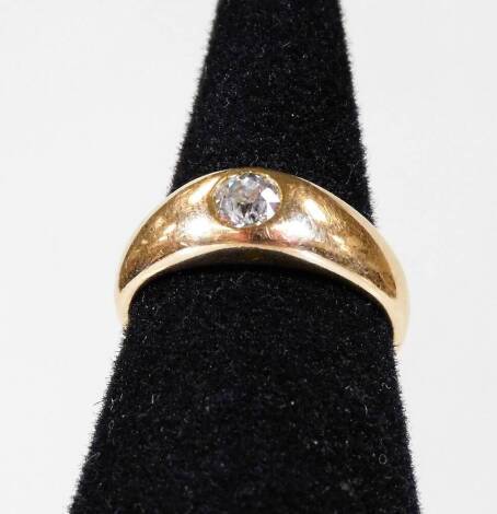 A diamond solitaire ring, with round brilliant cut stone in rub over setting, approx 0.2cts, on a yellow metal band, unmarked, ring size K, 4.8g all in.