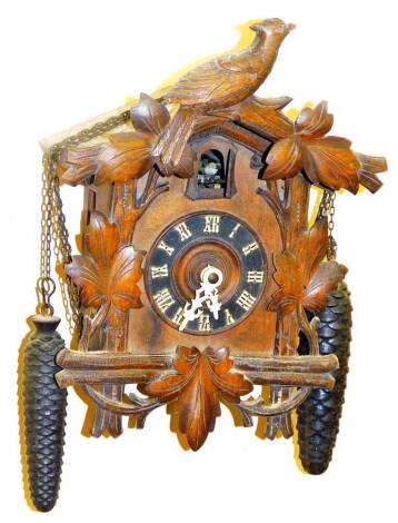 A 20thC Black Forest cuckoo clock, with shaped carved case, 9cm Dia Roman numeric dial and articulated bird movement, with chain and two weights, 31cm H.