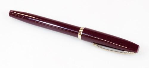 A Sheaffer fountain pen, in burgundy with banding and shaped clip, and partially enclosed nib, 14cm W.