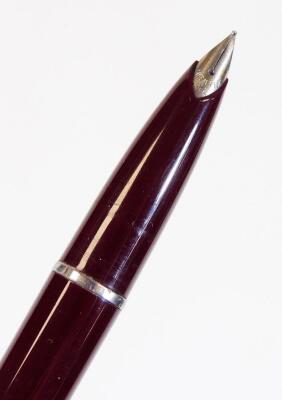 A Sheaffer fountain pen, in burgundy with banding and shaped clip, and partially enclosed nib, 14cm W. - 2