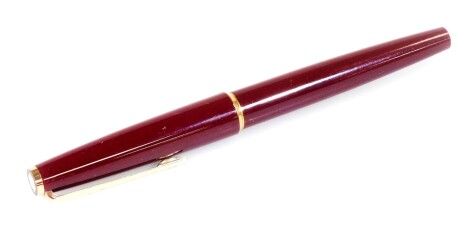 A Montblanc Classic fountain pen, in burgundy with gilt coloured clip and banding, with star to the lid top, nib marked Mont Blanc, 13cm W.