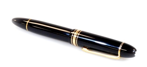 A Montblanc fountain pen no.149 Meisterstuck, black with gilt clip and banding, with star to the top of the lid and 18k two coloured nib, 15cm W.