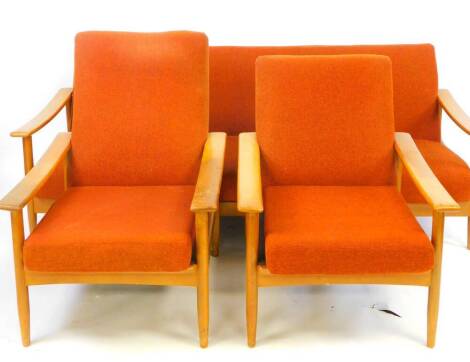 A vintage 1970s three piece lounge suite, comprising settee and two armchairs, each with turned legs joined by front to back stretchers, in orange material, the settee 77cm H, 191cm W, 85cm D. The upholstery in this lot does not comply with the 1988 (Fire