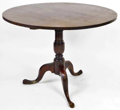 An early 19thC tilt top supper table, the circular top on a gun barrel stem terminating in triple cabriole legs, when raised 126cm H, the top 95cm Dia.