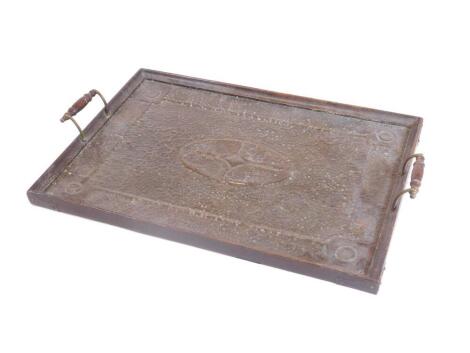 An early 20thC oak framed tray, with heavily hammered metal centre and shaped handles, 54cm W.