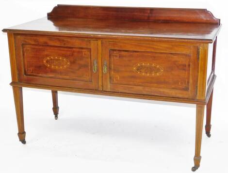 An Edwardian mahogany dressing table, of rectangular form, with double cupboard to the front, on square tapering legs, terminating in spade feet and castors, 85cm H, 123cm W, 55cm D.