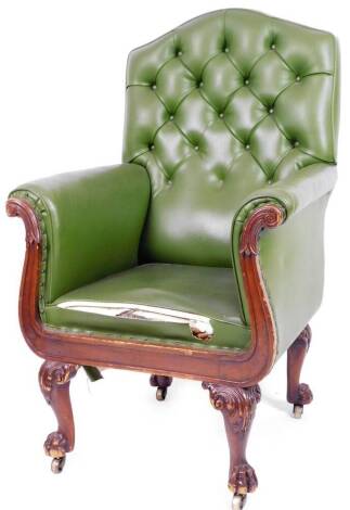 A 19thC mahogany library armchair, with button back arms and seat upholstered in later green leather, on scroll topped hairy paw feet terminating in castors, 122cm H.