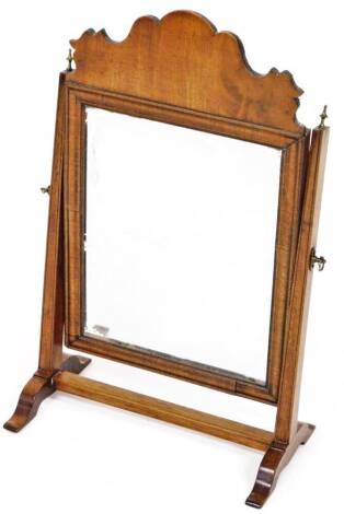 A 19thC mahogany table mirror, with carved top raised above a plain rectangular glass flanked by square supports, with brass urn finials, on scroll feet joined by a plain horizontal stretcher, 45cm H, 29cm W, 15cm D.