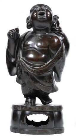 A Japanese Meiji period bronze figural koro, formed as the standing figure of Hotei, the God of Good Fortune, his sack with removable cover, on pierced quatrelobed base, unmarked, 26cm H.