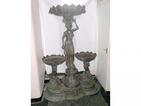 A modern bronze fountain of classical design with central figure flanked