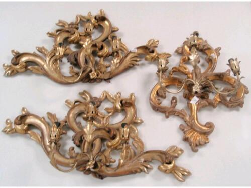 A garniture of three Italian carved wooden wall sconces in Rococo-style with metal mounts