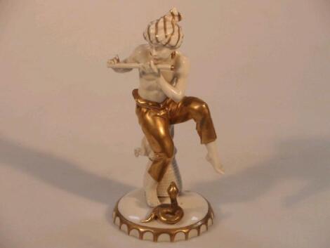 A Sitzendorf ivory glaze figure of a snake charmer