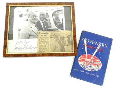 A photograph of two German airmen returning to the city of Coventry to commemorate the 40th Anniversary of the raid, comprising of press photograph, press clipping and signatures of Heurgunta Unger and Heur Lukesh Diether, also Coventry Under Fire by the